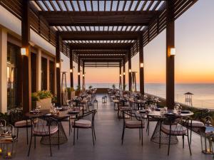 a restaurant with tables and chairs on the beach at Rixos Water World Aktau - Theme Park Free Access in Aktau