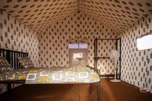 a bedroom with a bed in a room with wallpaper at Rann Rajvi Homestay in Dhordo