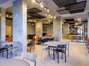 a dining room with tables and chairs in a building at ibis Ribeirao Preto Vila do Golf in Ribeirão Preto