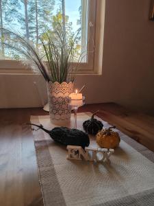 a table with vegetables and a candle and a window at Villa Tammikallio Guest House, near the airport - Kodikas vierasmaja Tuusulassa in Tuusula