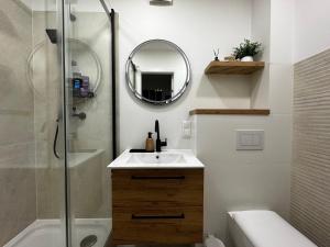 a bathroom with a sink and a shower and a mirror at Apartament Muzyczny Kącik przy Rynku in Świdnica +8 photos