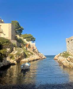 a boat in a river next to a castle at Al Baglio di Sant'Elia in Santa Flavia