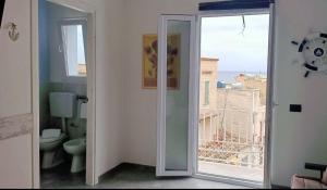 a bathroom with a toilet and a window with a view at Al Baglio di Sant'Elia in Santa Flavia