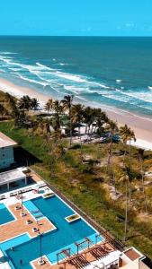 a view of the beach from the balcony of a resort at Apartamento Pé na Areia in Ilhéus