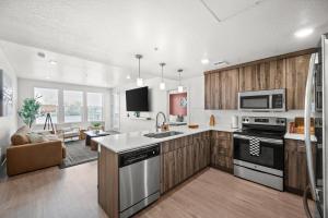 214 North Temple CondominiumModern Downtown 2BR 2BA with City Views Fire Pit Walk to Delta Center的一间带木制橱柜的厨房和一间客厅