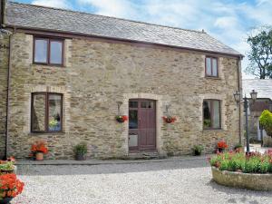 an old stone house with flowers in front of it at Penty Rosen in Pentewan