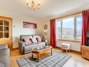 un salon avec un canapé et une table dans l'établissement Bramble Cottage, à Gairloch