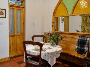 Church Cottage في Rigg: غرفة طعام مع طاولة ومرآة