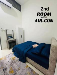 - une chambre avec un lit bleu et un canapé dans l'établissement Puteri Resident In Stay, à Sungai Petani