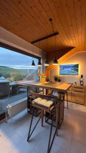 a dining room with a table and chairs and a large window at HTS Mosel Apartment Wanderlust Bernkastel Andel in Bernkastel-Kues