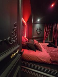 a bedroom with a bed with red lighting at Elisabeta Suite - Eternal Romance with Balneo XL in Chamalières