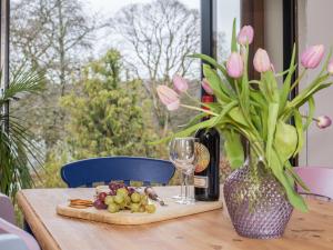 a table with a plate of food and a glass of wine at Harewood Barn in Brompton Regis