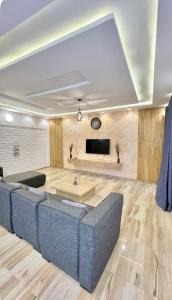 a living room with a blue couch and a flat screen tv at trois chambres et salon avec balcon à Porto Novo in Porto-Novo
