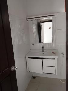 a white bathroom with a sink and a mirror at Golden Heavens kengalla in Kandy