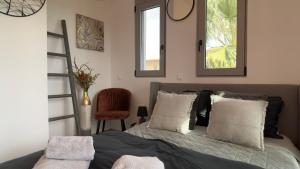 a bedroom with a bed with two mirrors on the wall at ARYVE Townhouse Rhodos mit Akropolis- und Meerblick sowie Jacuzzi und tollen Sonnenterrassen und Garten in Malona Village