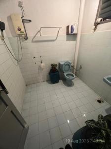 a bathroom with a blue toilet and a sink at There's A Borneo Guesthouse in Johor Bahru