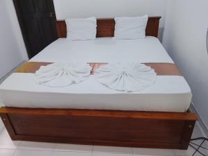 a bed with white sheets and pillows on it at Golden Heavens kengalla in Kandy