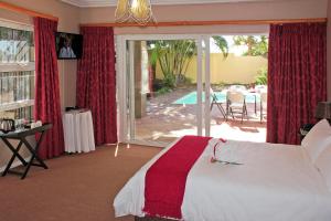 une chambre avec un lit et une vue sur une piscine dans l'établissement Durban Manor Guest House, à Durban 55 autres photos