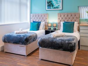 two beds in a room with blue walls at Hilltop Apartment 3 - Uk50595 in Earl Shilton +4 photos