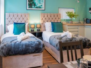 a bedroom with two beds and a table and a kitchen at Hilltop Apartment 3 - Uk50595 in Earl Shilton