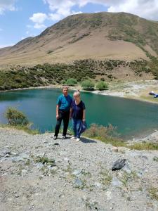 two people standing in front of a body of water at Kf guest house 2 in Shabdan