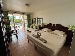 um quarto com uma cama com dois chinelos em Suite Paradis Village Vacances Vue mer & piscine em Sainte-Luce mais 18 fotografias