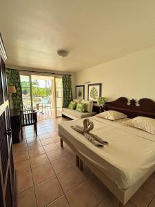 um quarto com duas camas e uma sala de estar em Suite Paradis Village Vacances Vue mer & piscine em Sainte-Luce