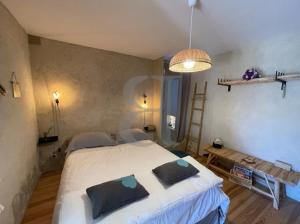 Un dormitorio con una gran cama blanca con almohadas. en Villa Férus Piscine chauffée, en Buis-les-Baronnies