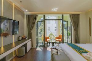 a hotel room with a bed and a balcony at HT House in Da Lat
