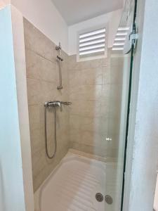 um chuveiro com porta de vidro em um banheiro em Suite Paradis Village Vacances Vue mer & piscine em Sainte-Luce