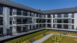 an apartment building with a playground in the courtyard at Apartament Jasny Spokój in Jantar