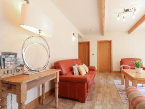 a living room with a red couch and a mirror at Sumner Lodge in Kyre Magna
