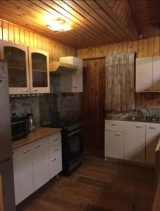 コキンボにあるCasa Guanaqueroのキッチン(白いキャビネット、黒いコンロ付)