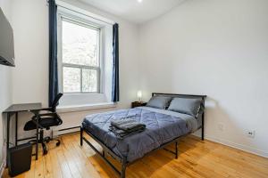 a bedroom with a bed and a desk and a window at Great apartment with parking in Montréal