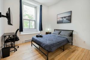 a bedroom with a bed and a desk and a chair at Great apartment with parking in Montréal