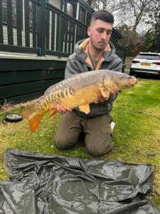 a man holding a large fish in his hand at Springs Southview Skegness in Winthorpe