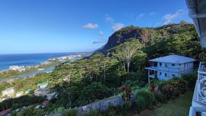 una casa en una colina junto al océano en Beau Soleil Stunning Sea View One Bedroom Apartment, en Mahe