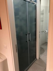 a glass shower door in a room with a bathroom at Siena, a due passi dal centro, posto auto incluso in Siena