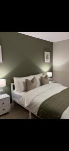 StaincrossにあるBeautiful Cosy Yorkshire Home - Newly Refurbishedの緑の壁と大きなベッドのある寝室