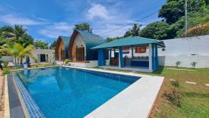 een zwembad voor een huis bij Maggona Boutique Cottages in Maggona West