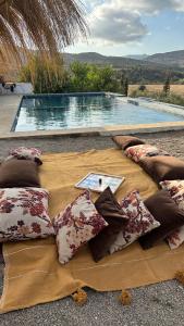 a blanket with pillows on it with a swimming pool at Dar Charkaoui in Tetouan