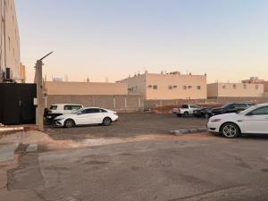 un groupe de voitures garées sur un parking dans l'établissement مساكن توليب للشقق الفندقية, à Arar