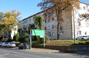 a green street sign in front of a building at Oliva Apartman in Salgótarján