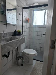 une salle de bain blanche avec un lavabo et des toilettes dans l'établissement Casa Jabuticabeira - Quarto disponivel, à Macapá