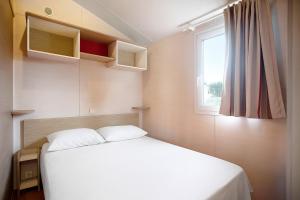 Un dormitorio pequeño con una cama y una ventana. en Nature's Avlis Bungalow 4XZ, en Pataias 25 fotos más