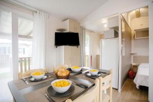 un comedor con una mesa con tazones de fruta. en Nature's Avlis Bungalow 4XZ, en Pataias