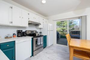 een keuken met witte en groene kasten en een tafel bij Outdoors, Hiking, Skiing Mountain Vacation Getaway in Tannersville