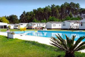 Una gran piscina en un patio con casas. en Nature's Avlis Bungalow 4XZ, en Pataias
