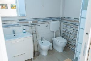 a bathroom with a toilet and a sink at Casetta Giardinetto in Altavilla Milicia +4 photos