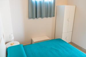 a small bedroom with a blue bed and a cabinet at Casetta Giardinetto in Altavilla Milicia